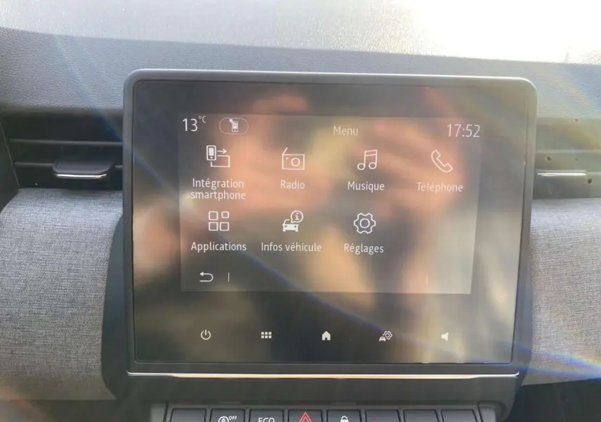 Écran tactile central de la Renault Clio 1.5 Blue dCi noir, affichant le menu principal avec intégration smartphone.