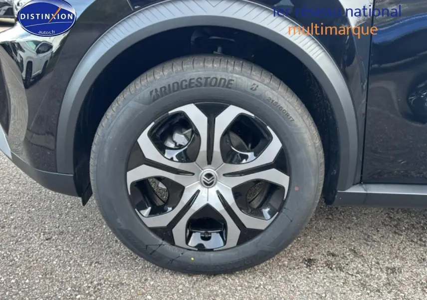 Gros plan sur la roue avant gauche noire d’un Citroën C3 Aircross 2025 avec jante 17 pouces bicolore.