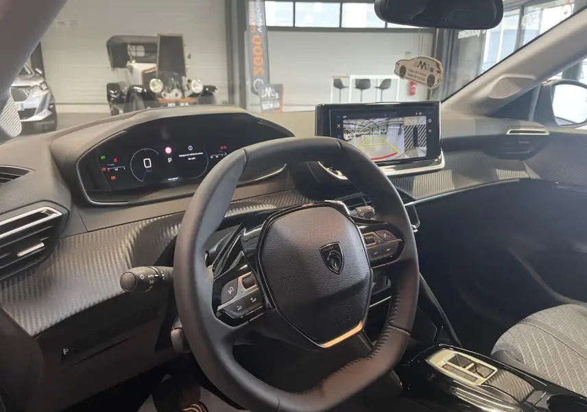 Vue intérieure côté conducteur du Peugeot 208 2025, volant compact cuir et tableau de bord numérique avec écran tactile.