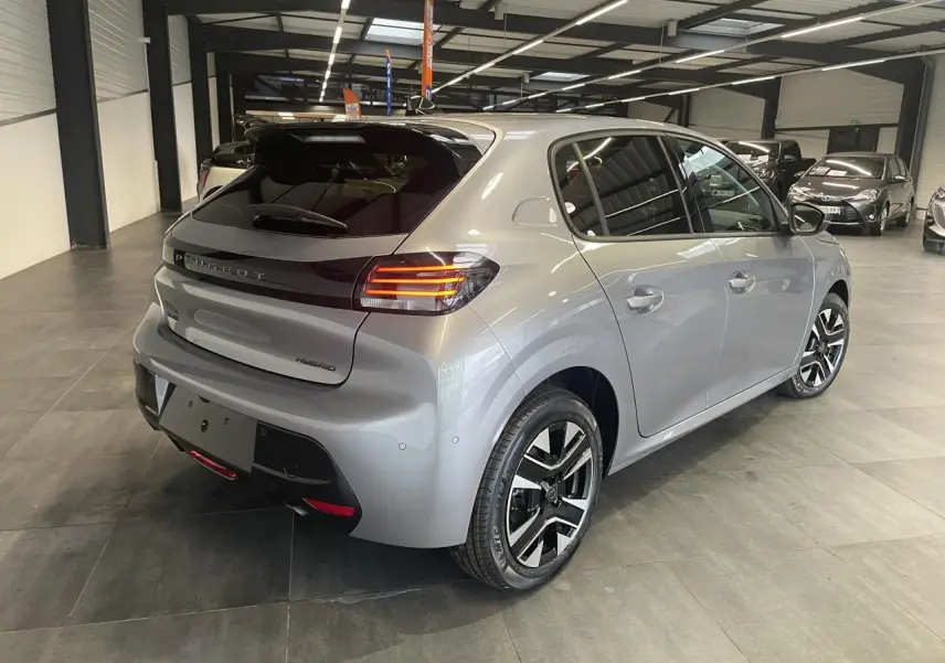 Peugeot 208 gris Artense vue 3/4 arrière droit en intérieur avec feux arrière LED et jantes alliage bi-tons.