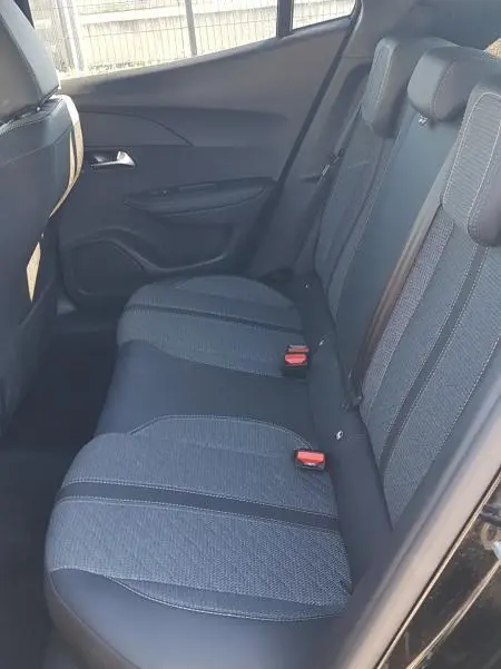 Vue intérieure côté gauche des sièges arrière noirs du Peugeot 2008 Hybrid 145 e-DCS6 Allure 2025, avec ceintures et appuie-têtes.
