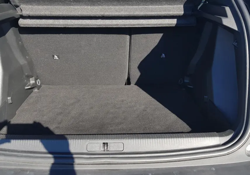 Coffre ouvert d’un Peugeot 2008 Hybrid 145 noir, vue de l’arrière montrant l’espace de chargement vide.