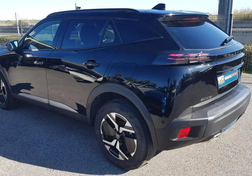 Vue 3/4 arrière droite d’un Peugeot 2008 Hybrid 145 noir avec jantes alliage 17 pouces et vitres teintées.