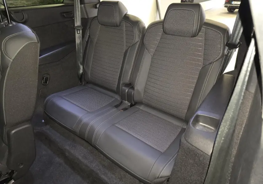 Vue intérieure du rang 3 du Peugeot 5008 gris 2025, montrant la banquette 2 places en tissu et cuir avec surpiqûres contrastées.