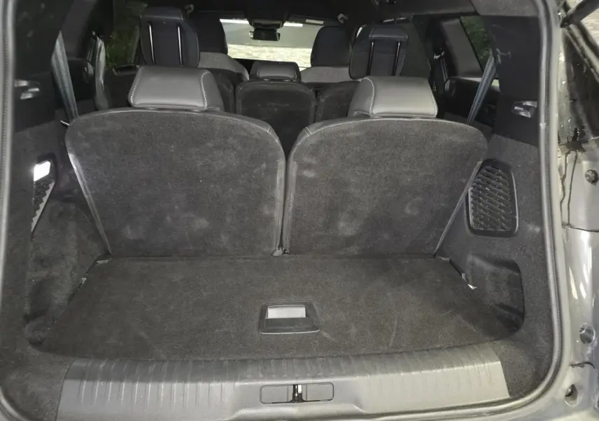 Vue arrière du coffre du Peugeot 5008 gris avec banquette troisième rangée relevée et intérieur noir.