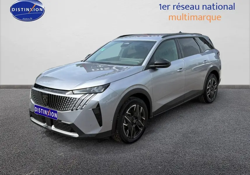 Peugeot 5008 Hybrid 145 gris Artense en 3/4 avant droit, avec calandre distinctive et jantes alu noires.