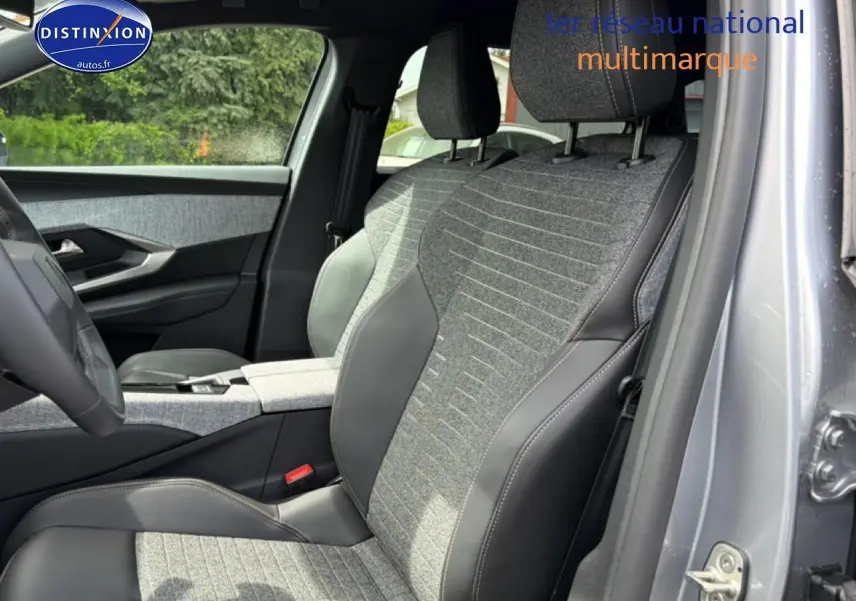 Vue intérieure côté conducteur du Peugeot 5008 gris artense, mettant en valeur les sièges tissu et cuir bicolores.