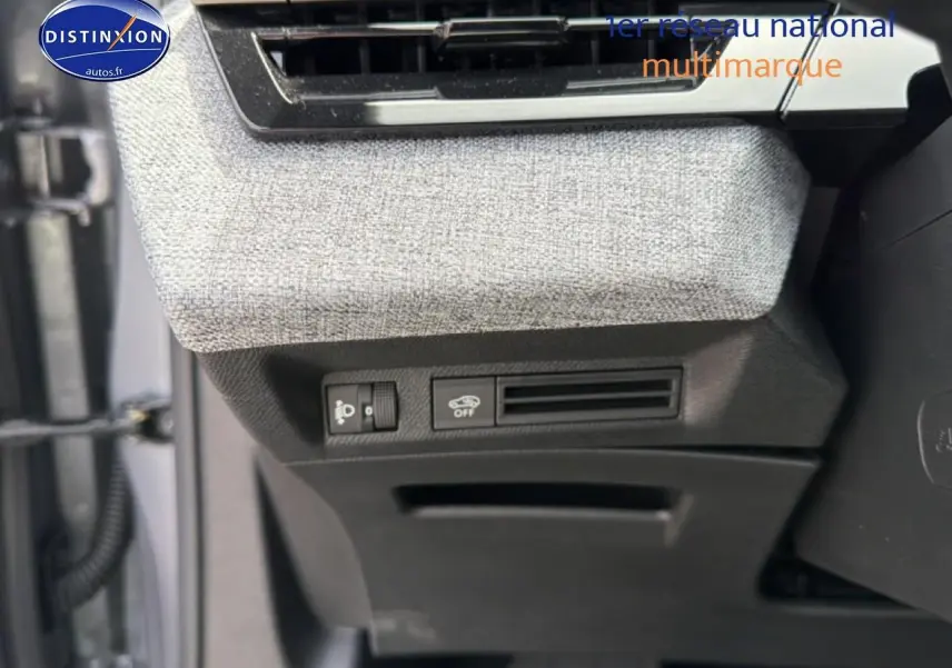 Détail des commandes sous la planche de bord côté gauche avec tissu gris et plastique noir du Peugeot 5008 Hybrid 145.