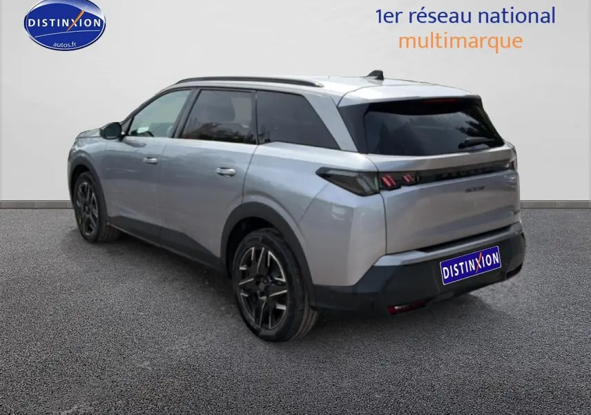 Vue 3/4 arrière droite d’un Peugeot 5008 Hybrid 145 gris artense avec vitres arrière surteintées et jantes alu noires.