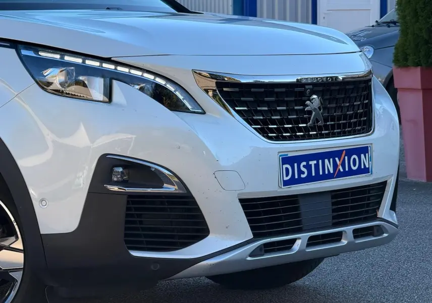 Vue arrière intérieure du Peugeot 3008 blanc nacré, montrant la banquette arrière en cuir et alcantara avec appuie-têtes intégrés.