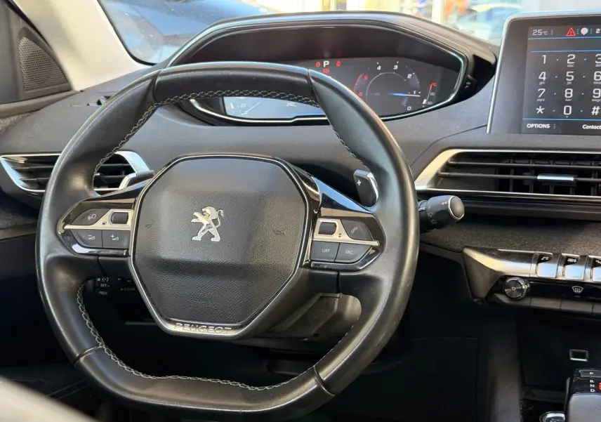 Vue de face rapprochée du Peugeot 3008 blanc nacré mettant en valeur sa calandre noire et ses phares LED distinctifs.