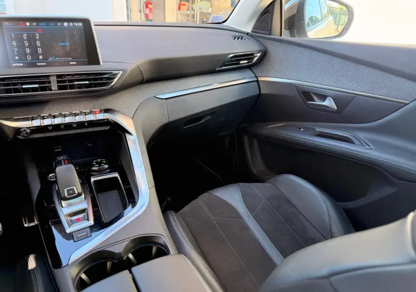 Gros plan sur le bouton d'ouverture du hayon du Peugeot 3008 blanc nacré, intérieur tableau de bord.