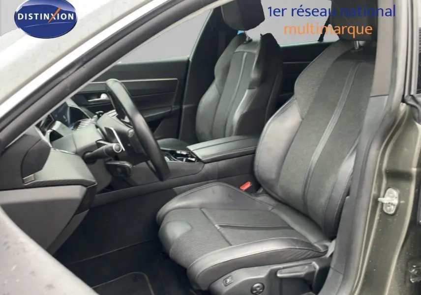 Vue intérieure côté conducteur de la Peugeot 508 SW gris amazonite, sièges mixtes cuir et tissu, volant multifonction.