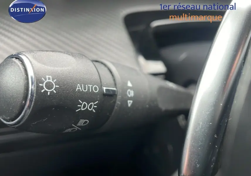 Gros plan sur la commande des phares automatiques à gauche du volant dans l’habitacle d’une Peugeot 508 SW gris Amazonite.