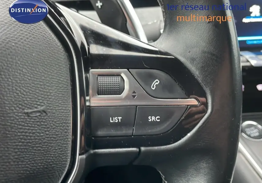 Gros plan sur les commandes gauche du volant en cuir noir de la Peugeot 508 SW 2020, avec boutons de téléphone et liste.