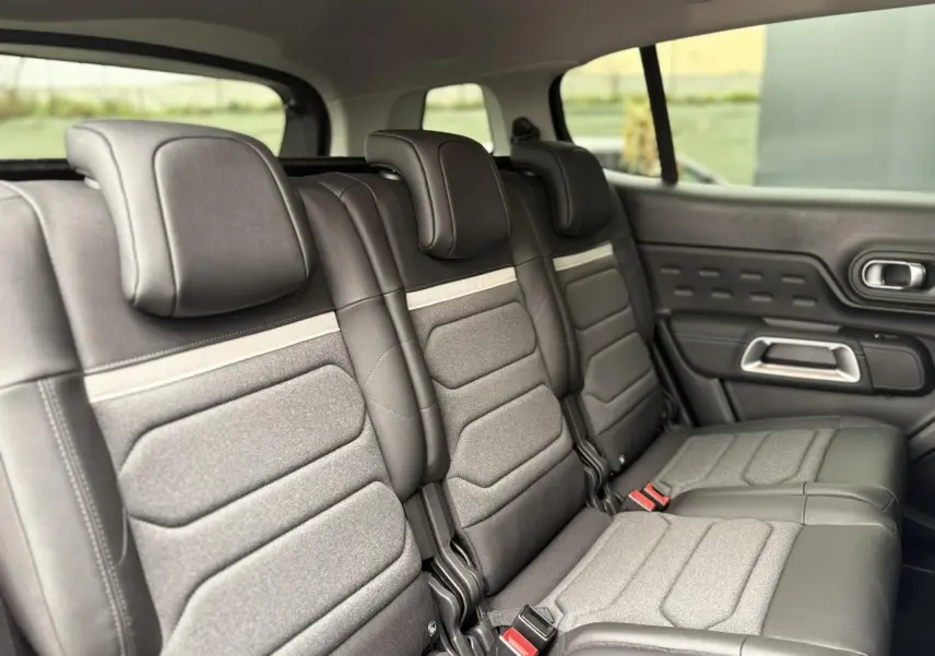 Vue latérale droite des trois sièges arrière indépendants en tissu et cuir noir du Citroën C5 Aircross Hybrid 2025.