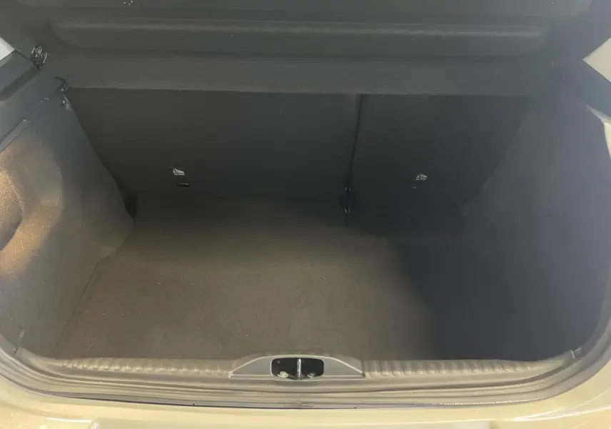 Coffre ouvert vu de face d'une Citroën C3 beige clair 2024, espace de rangement vide et propre.