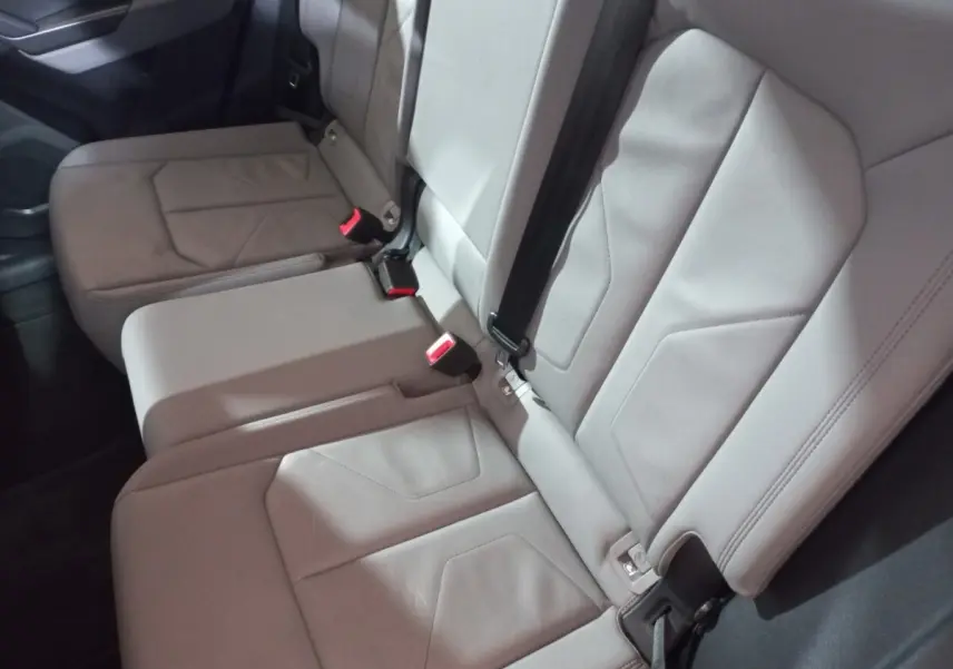 Vue rapprochée de la banquette arrière grise de l'Audi Q3 45 TFSI E 245 S tronic S line avec ceintures et boucles rouges.