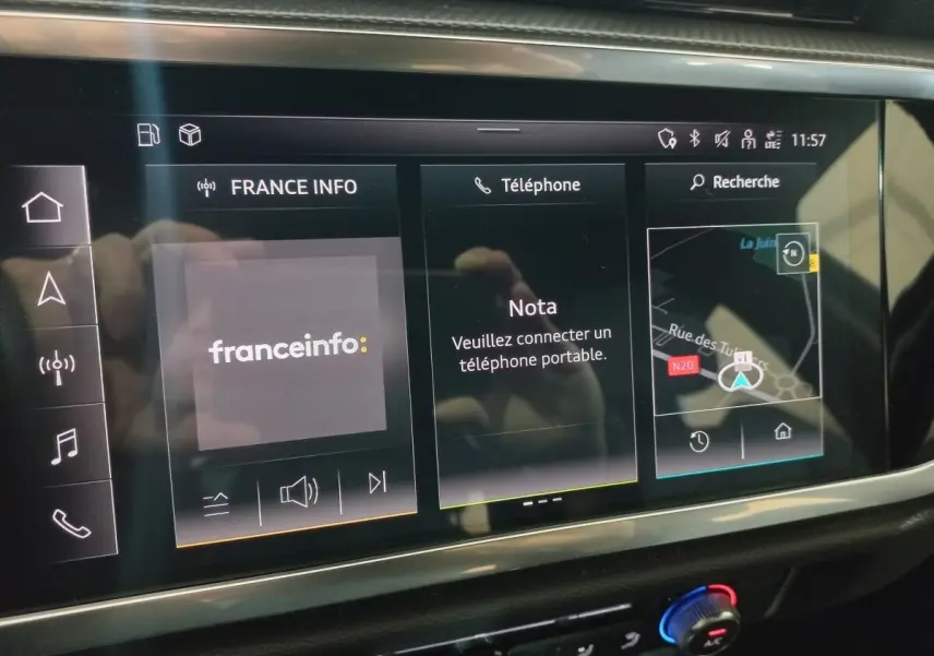 Écran tactile central de l’Audi Q3 blanc 45 TFSI E 2021 affichant radio, téléphone et navigation GPS.