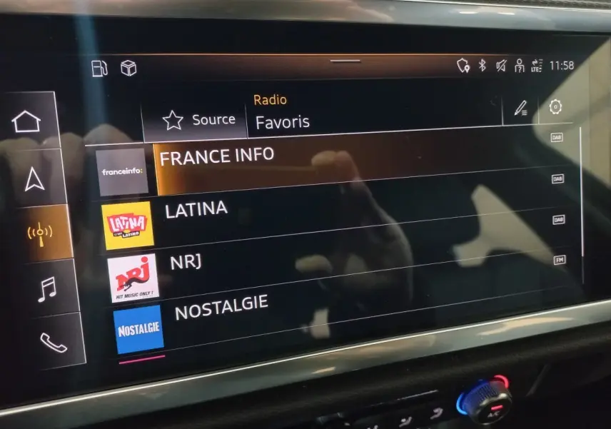 Écran tactile multimédia de l'Audi Q3 blanc, affichant les stations radio favorites en intérieur.