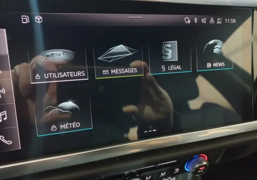 Écran tactile central de l'Audi Q3 blanc 45 TFSI E 2021 affichant les menus Utilisateurs, Messages, Légal, News et Météo.