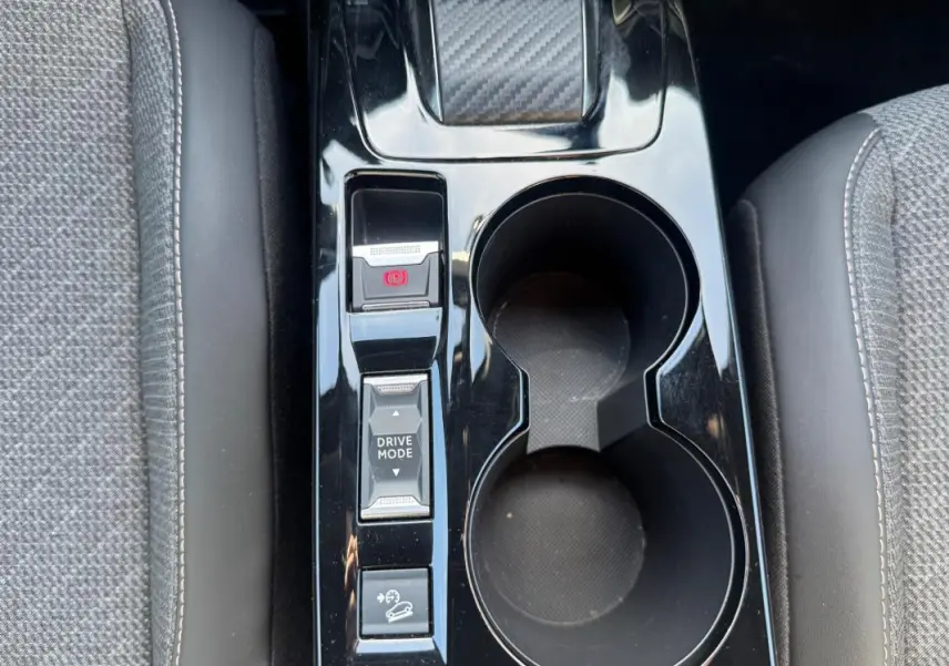 Vue plongeante sur la console centrale noire du Peugeot 2008 Hybrid 136 e-DCS6 Allure avec boutons Drive Mode et frein à main électrique.