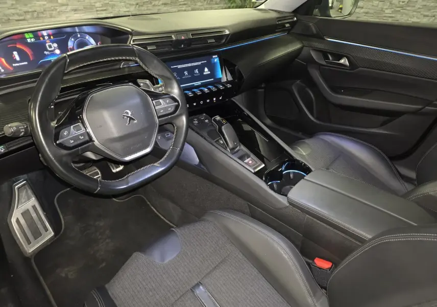 Vue intérieure côté conducteur de la Peugeot 508 SW noire, avec tableau de bord numérique et volant compact cuir.