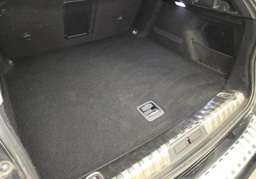 Coffre noir spacieux de Peugeot 508 SW 2019, vue intérieure avec tapis et filet de rangement latéral.