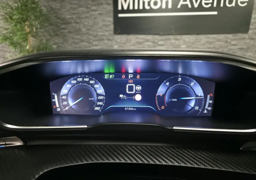 Vue rapprochée du combiné numérique Peugeot 508 SW 2019 avec affichage digital lumineux et décor carbone.