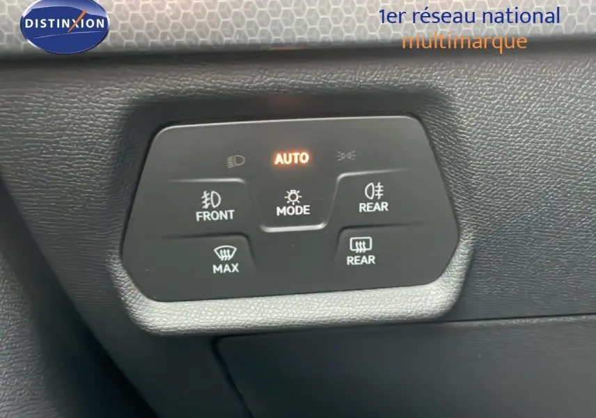 Panneau de commande des feux et dégivrage arrière sur tableau de bord noir d'une SEAT LEON 2025.