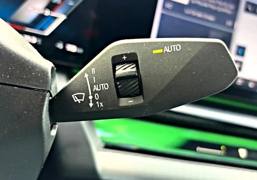 Gros plan sur la commande d’essuie-glace avec réglage automatique dans l’habitacle noir d’une BMW Série 5 i5 M60 2024.