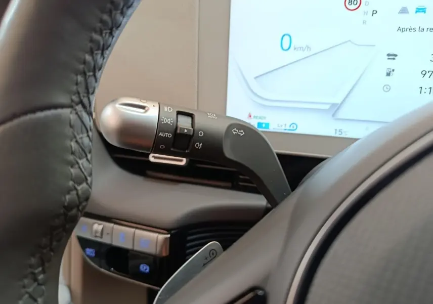 Gros plan sur la commande de clignotants et partie du volant cuir beige d'une Hyundai IONIQ BEV 77KWH AWD Executive 2023.