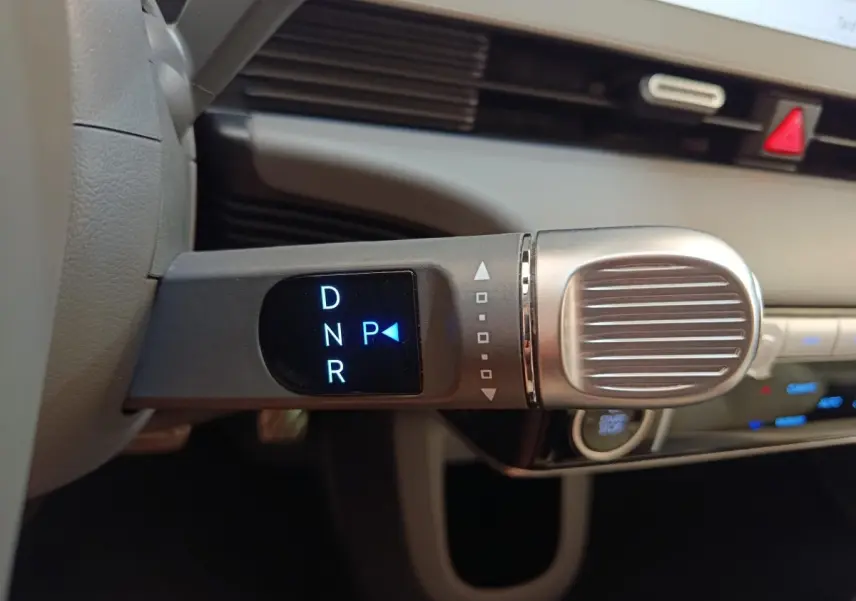 Gros plan sur la commande de boîte automatique avec affichage digital dans l’habitacle beige du Hyundai IONIQ 2023.