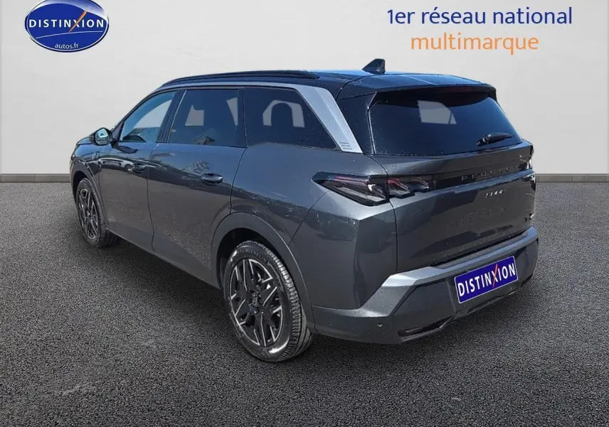 Vue 3/4 arrière droite d'un Peugeot 5008 Hybrid gris titane avec jantes alu et vitres surteintées.