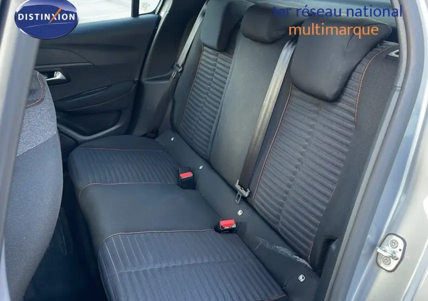 Vue intérieure sur la banquette arrière en tissu gris noir avec surpiqûres orange d'une Peugeot 208 électrique gris Artense.