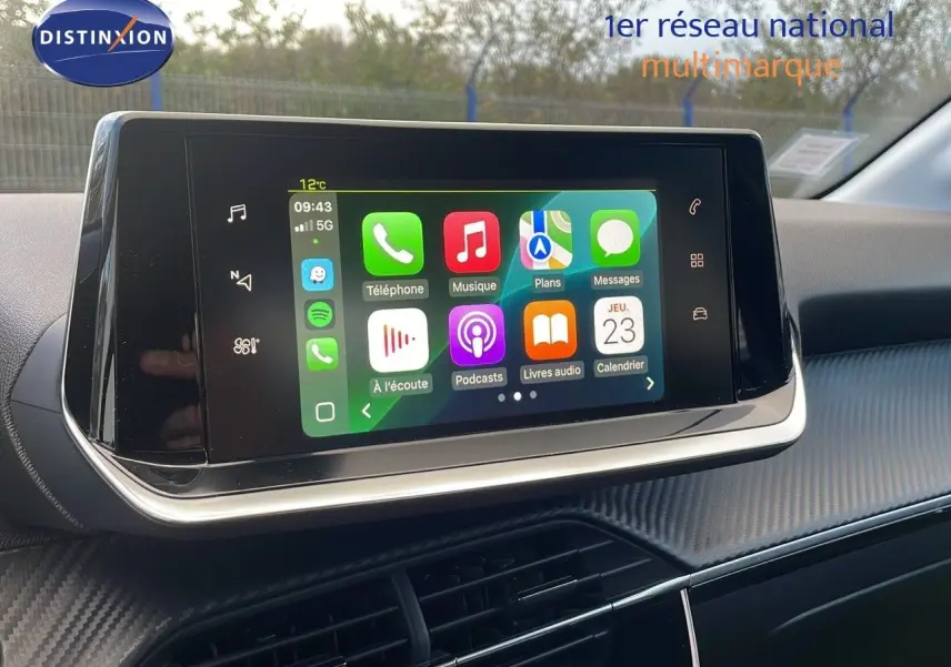 Écran tactile central affichant les applications connectées, intérieur moderne de la Peugeot 208 électrique gris Artense.