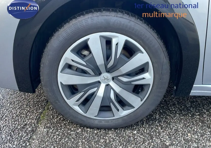 Gros plan sur la roue avant gauche de la Peugeot 208 électrique gris Artense, soulignant la jante au design moderne.