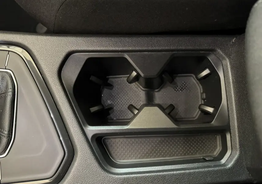 Gros plan sur les porte-gobelets noirs au centre de la console d’un Volkswagen Tiguan bleu 2021.