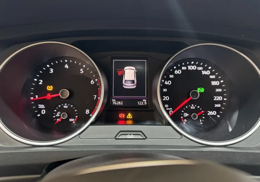 Vue rapprochée du tableau de bord du Volkswagen Tiguan 2021, affichant les compteurs et l'alerte porte ouverte.