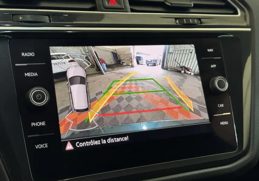 Écran tactile central du Volkswagen Tiguan 2021 affichant la caméra de recul avec lignes de guidage colorées.