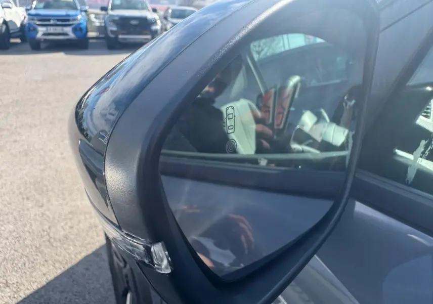 Rétroviseur extérieur côté gauche du Peugeot 2008 Hybrid 145 gris, avec clignotant intégré visible en extérieur.