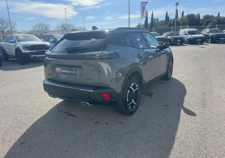 Peugeot 2008 Hybrid 145 gris en 3/4 arrière droit, jantes alliage 17 pouces et feux arrière LED distinctifs.