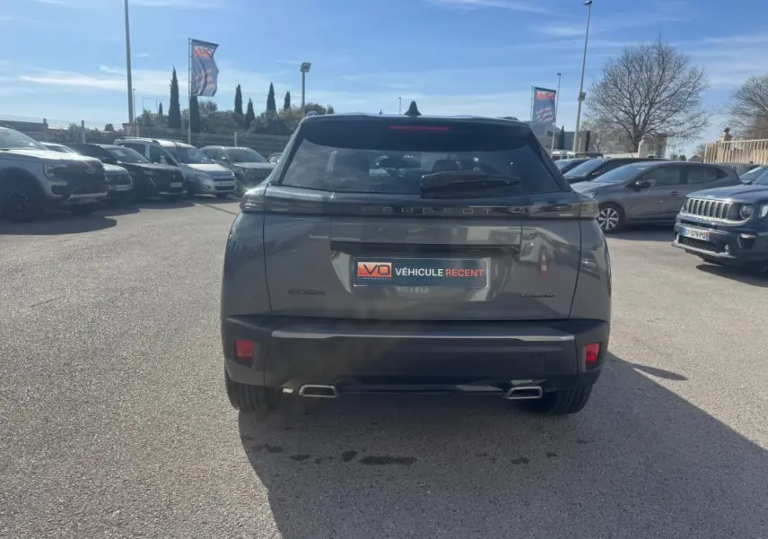 Vue arrière d'un Peugeot 2008 Hybrid gris 2025 avec feux LED et double sortie d'échappement rectangulaire.