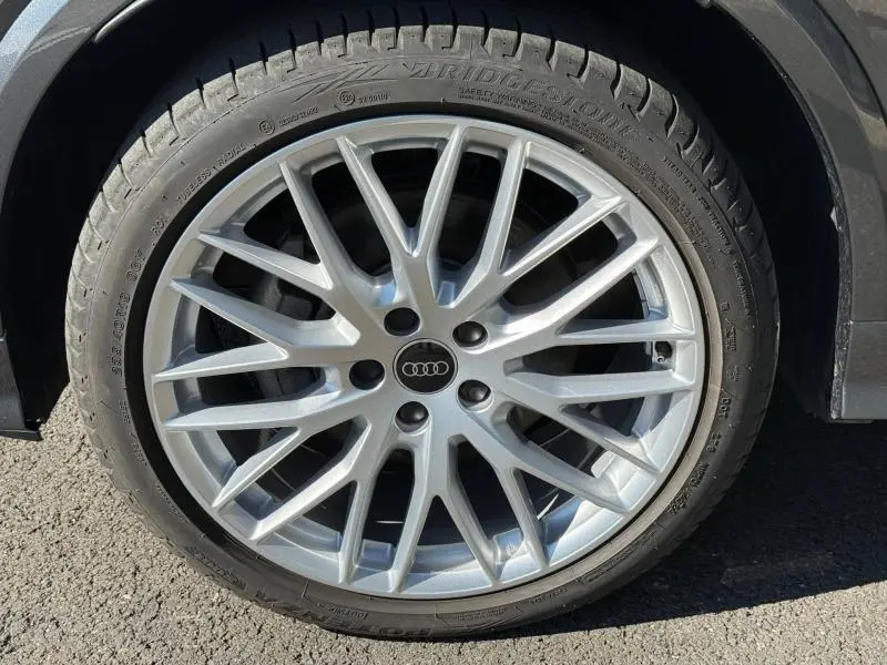 Gros plan sur la jante alliage argentée à multiples branches de l'Audi Q2 35 TDI S line 2025 en Gris Daytona nacré.
