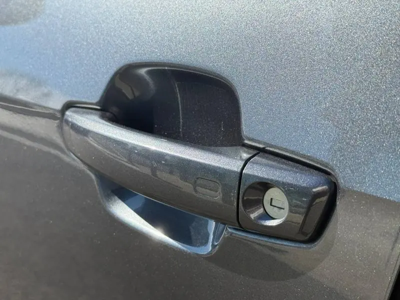 Poignée de porte avant droite de l'Audi Q2 35 TDI S line 2025 en gris Daytona nacré avec serrure visible.