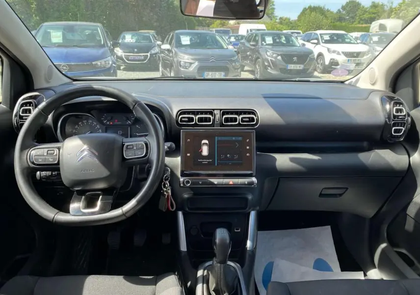 Vue intérieure frontale du tableau de bord du Citroën C3 Aircross gris Artense, avec volant multifonction et écran tactile central.
