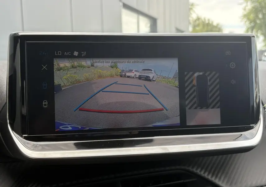 Écran tactile intérieur montrant la caméra de recul d’une Peugeot 208 Hybrid 110 e-DSC6 GT en stationnement.