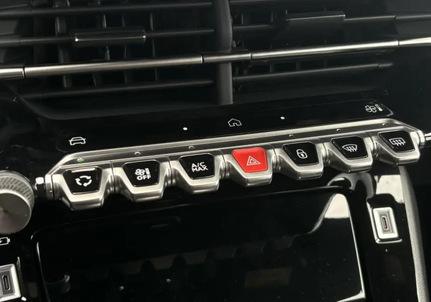 Vue rapprochée de la console centrale noire de la Peugeot 208 Hybrid 110 e-DSC6 GT avec boutons de commande argentés et rouge d’alerte.