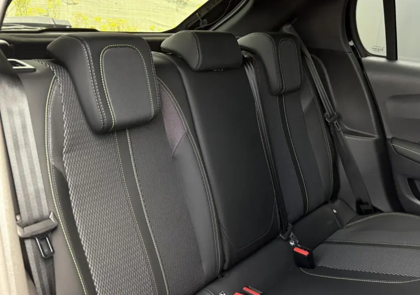 Vue intérieure sur la banquette arrière noire avec surpiqûres vertes de la Peugeot 208 Hybrid 110 e-DSC6 GT.
