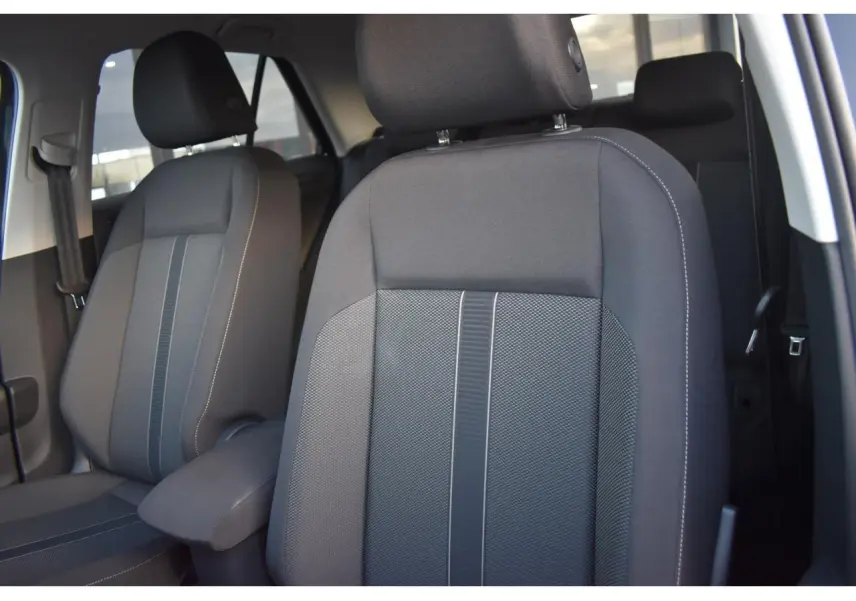 Gros plan sur les sièges avant en tissu noir et gris du Volkswagen T-Roc 2025, intérieur spacieux et moderne.